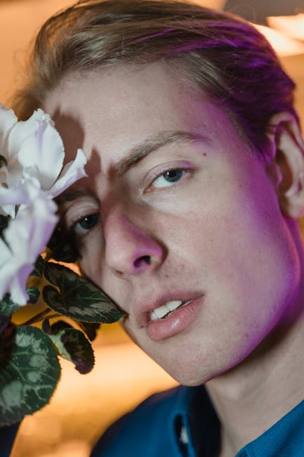Ritratto di un giovane uomo con un fiore bianco, espressione personale e creatività nell'arte e nella fotografia contemporanea.
