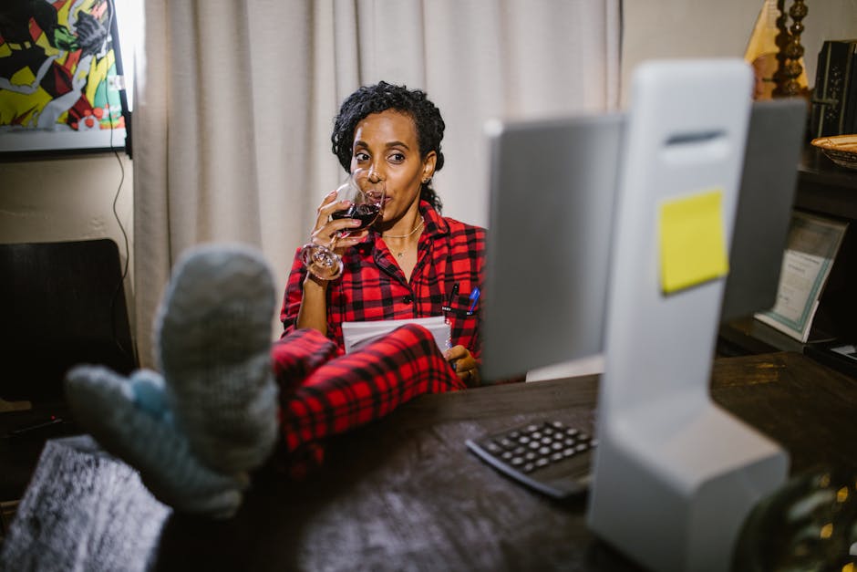 Donna in pigiama a quadri beve vino davanti al computer, metafora apprendimento flessibile e personalizzato