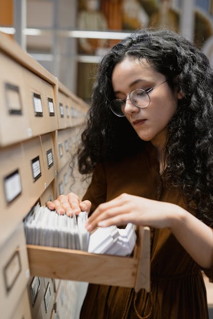 Donna che cerca schede didattiche sul sistema solare in un archivio, utili per l'apprendimento e lo studio dei pianeti.