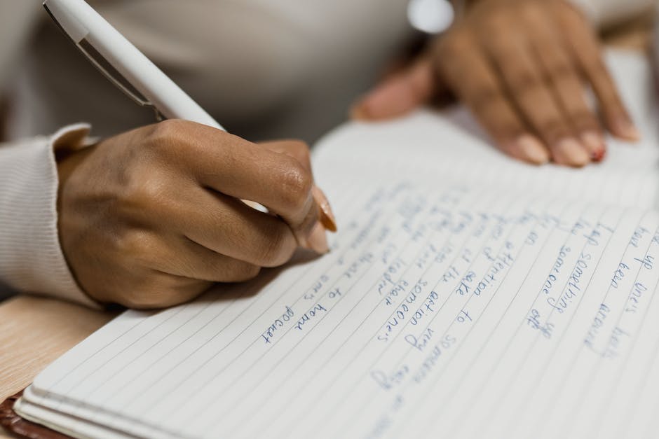 Diario emotivo a scuola: mano scrive su quaderno, strumento per gestire le emozioni e favorire l'espressione personale degli studenti.