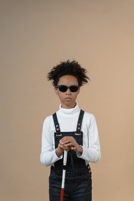 Ragazzo non vedente con occhiali scuri e bastone bianco: importanza dell'errore nell'apprendimento e nell'autonomia infantile