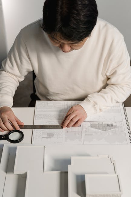Architetto al lavoro su piano passante per tre punti, analisi dettagliata del progetto con righello e lente d'ingrandimento.