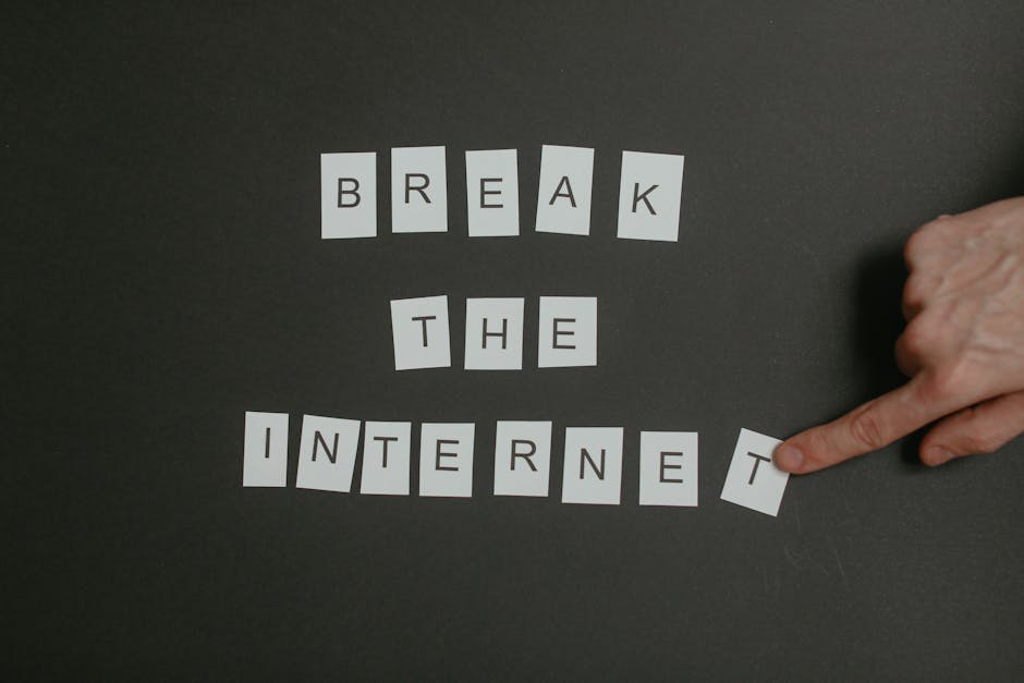 Insegnanti sotto pressione: dito che sposta la lettera T da INTERNET, metafora del cyberbullismo e della violenza online contro i docenti.
