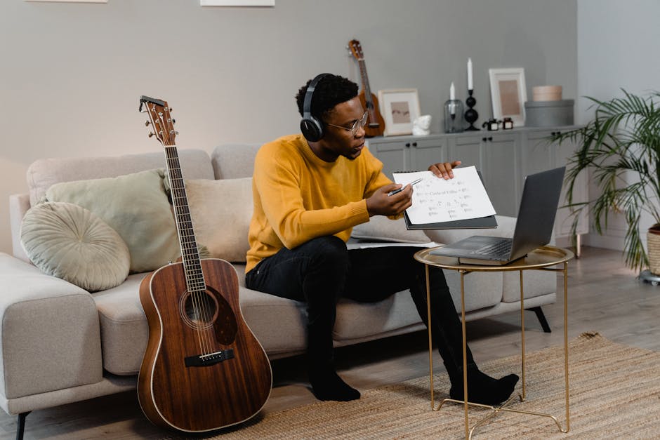 Insegnante di musica online mostra spartito durante corso Centro Goitre per insegnanti, chitarra acustica e laptop in primo piano