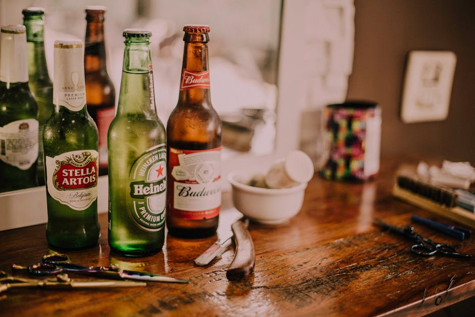 Bottiglie di birra Stella Artois, Heineken e Budweiser su tavolo di legno, elementi di laboratorio e strumenti di misurazione ottica visibili