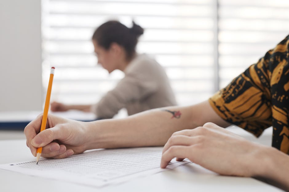 Studente compila test d'ingresso universitario con matita. Focus sulla preparazione ai test CISIA e INVALSI e difficoltà delle matricole.