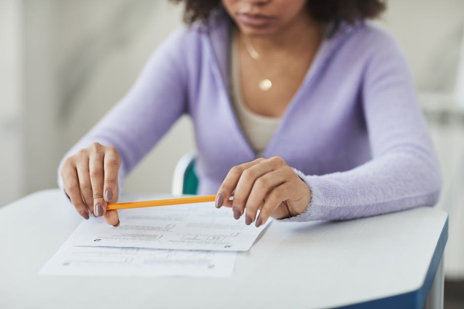 Studentessa concentrata su un compito scritto con matita, valutazione alternativa e nuovo paradigma educativo in primo piano.