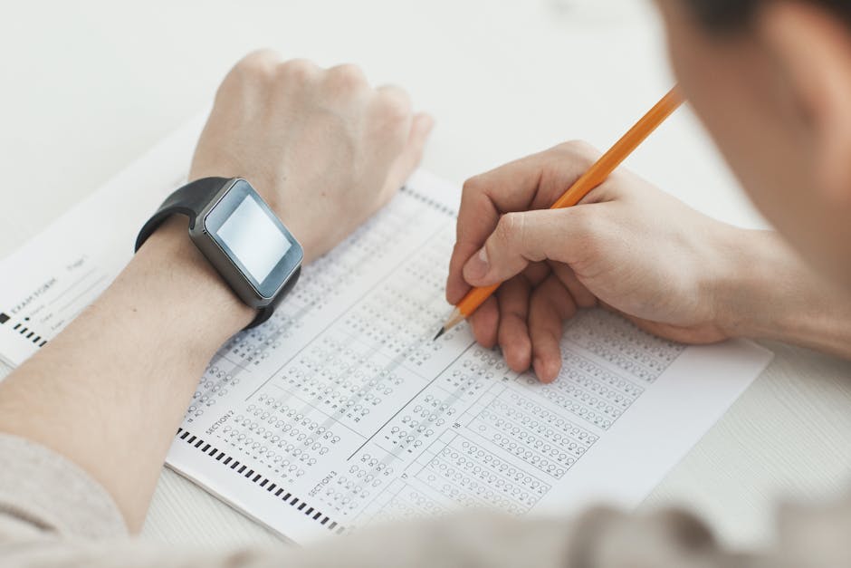 Studente universitario compila test a crocette con smartwatch al polso, simbolo del ritorno agli esami in presenza dopo l'era digitale.