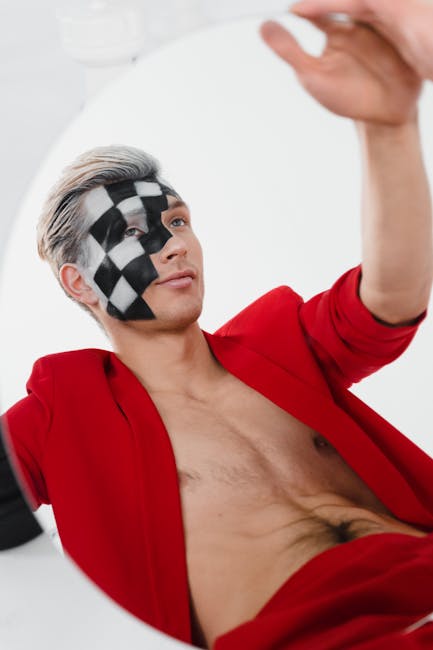 Approccio innovativo: uomo con scacchiera sul viso Uomo con scacchiera dipinta sul viso e giacca rossa, metafora di strategie innovative per superare le sfide attuali con creatività e visione.