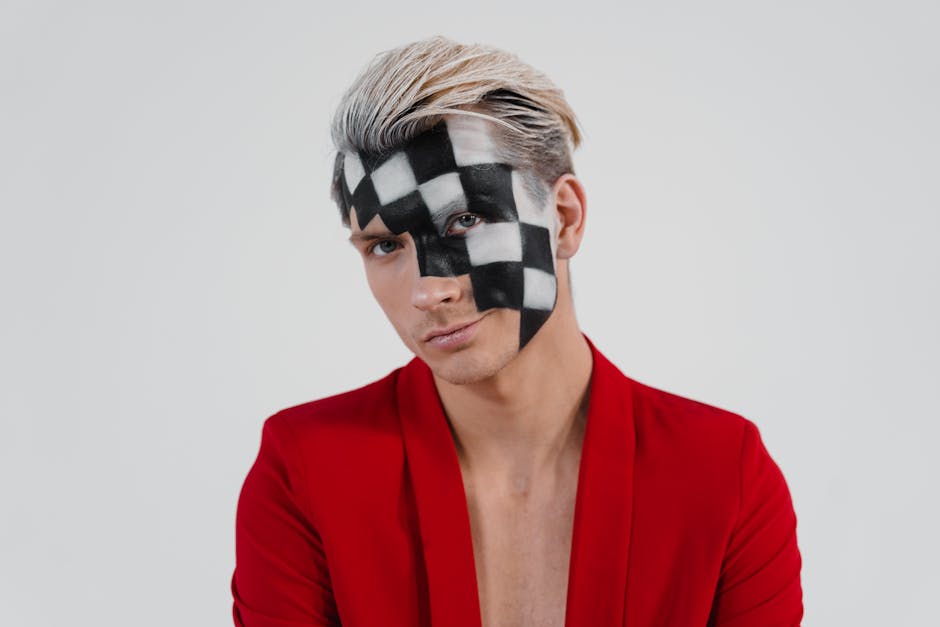 Ritratto di uomo con trucco a scacchi sul viso e giacca rossa, simbolo di strategia e resilienza come la Regina dei Volsci.