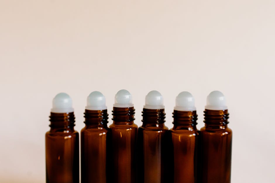 Flaconi roll-on marroni allineati per oli essenziali: semplifica la tua routine con il minimo comune multiplo unico per organizzare i tuoi prodotti.