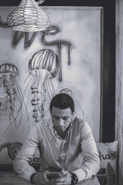 Uomo concentrato sullo smartphone: riflessioni sulla crescita dei figli e la protezione dalle difficoltà secondo Lancini