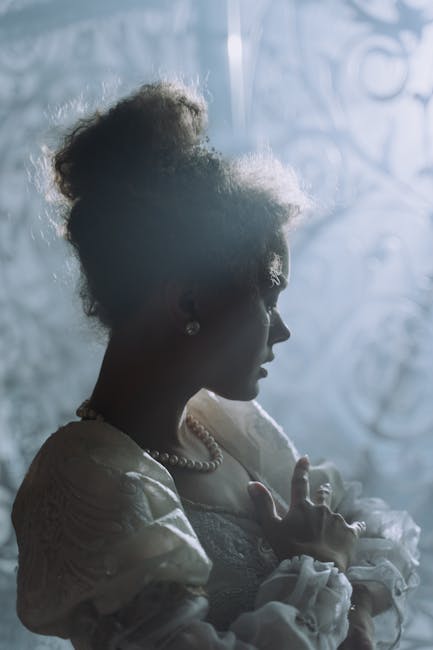 Ritratto in controluce di una figura femminile in abito d'epoca, evocativo di Maria la Sanguinaria, simbolo di terrore e potere femminile.