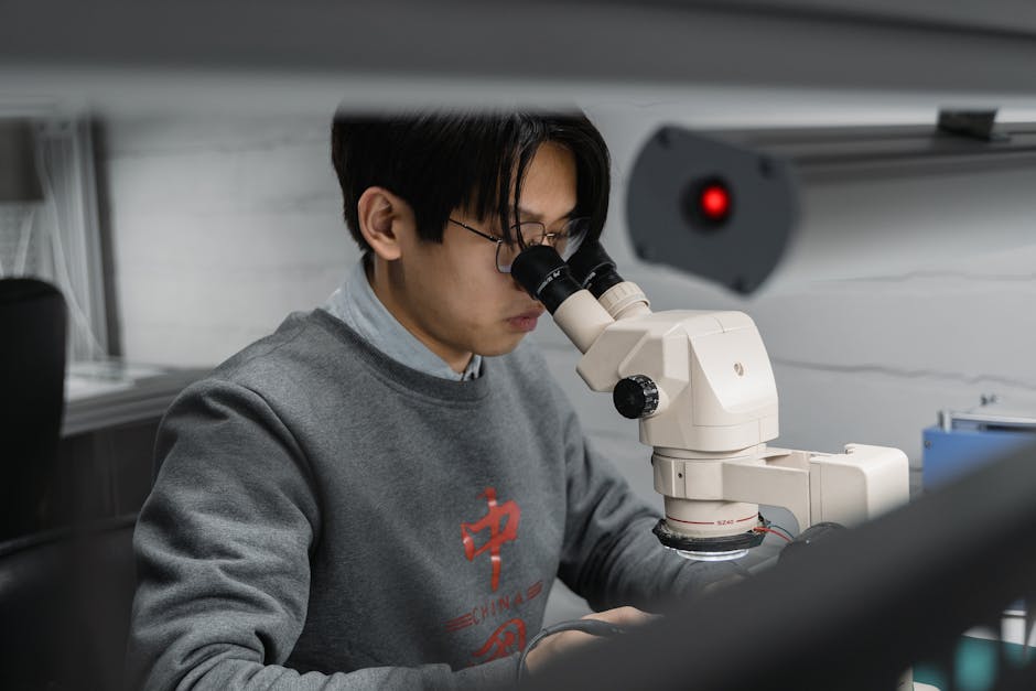 Ricercatore al microscopio per un'analisi precisa, elemento chiave nella valutazione efficace dei dati e dei risultati scientifici.