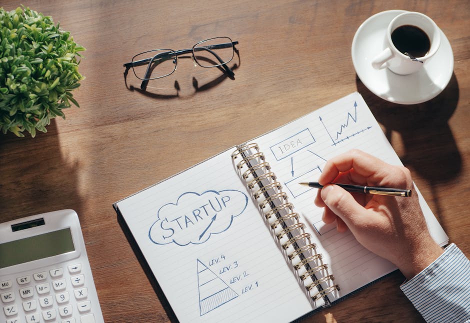 Concetti di startup e potenziale unico: mano che disegna diagrammi su quaderno con calcolatrice, occhiali e caffè.