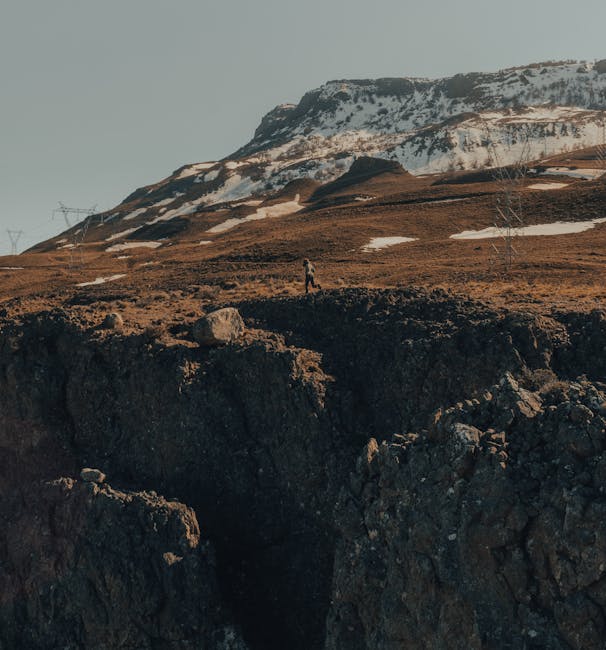 Metafora visiva della precarietà: figura solitaria su terreno impervio, montagna innevata sullo sfondo, simbolo delle sfide affrontate dagli insegnanti.