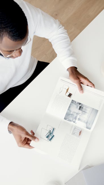 Giovane professionista esamina brochure di architettura, ispirazione per il futuro della Pubblica Amministrazione e nuove idee.