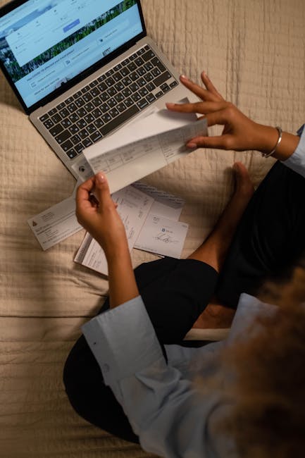 Insegnante confronta verifiche cartacee con dati su laptop, valutando l'uso dell'IA per la correzione nel contesto scolastico moderno.