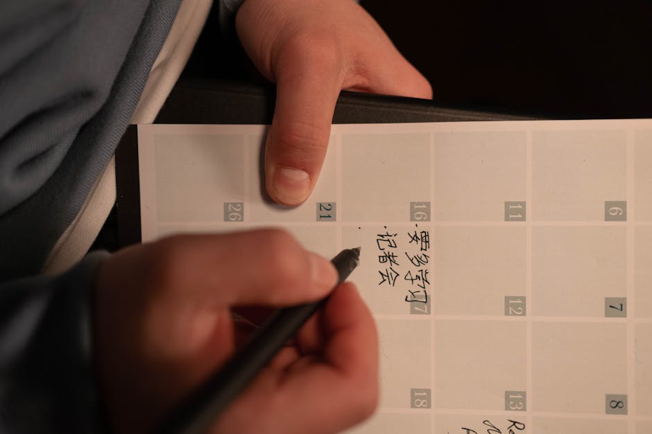 Mano che scrive su un diario scolastico personalizzato con calendario, ideale per organizzare studio e impegni scolastici con stile.