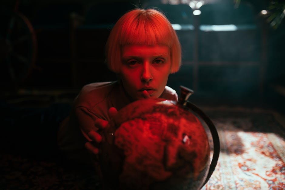 Donna con mappamondo illuminato di rosso, riflessione sul conoscere e progetti di pensiero filosofico profondo