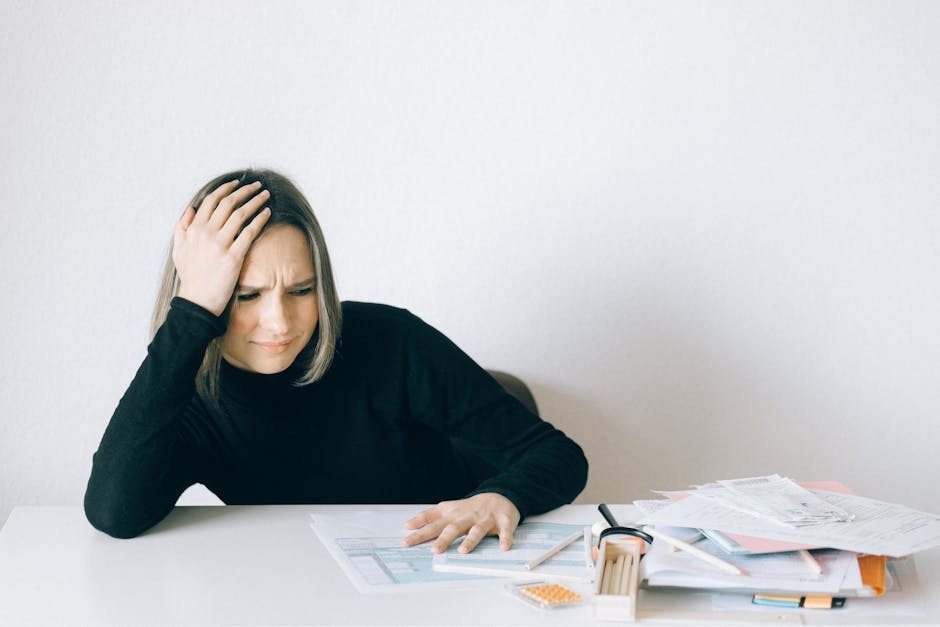Insegnante precaria stressata con documenti: simbolo della crisi del precariato scolastico italiano e le sue conseguenze emotive.