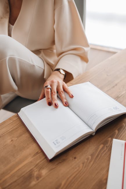 Donna che pianifica il tempo di lettura su un'agenda aperta, annotando informazioni per assimilare meglio i concetti chiave.