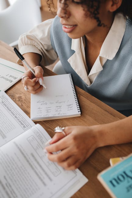 Studentessa concentrata che prende appunti per il suo profilo, studio approfondito e comprensione dei dettagli aggiuntivi.