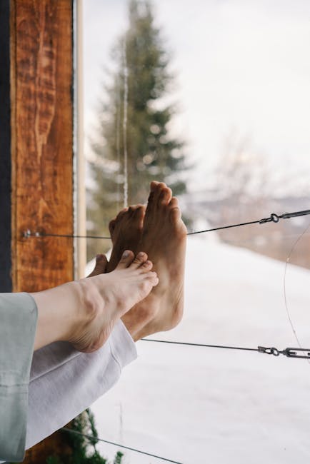 Piedi rilassati davanti al panorama invernale: metafora del calore e comfort dopo esercizi di fisica termodinamica