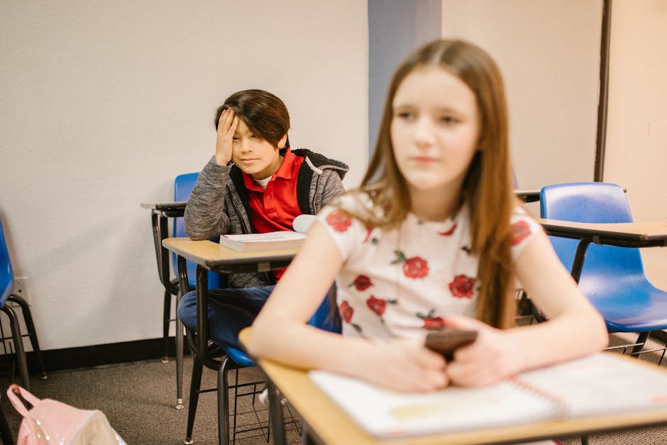 Adolescente pensieroso in classe: il bullismo e il ruolo degli insegnanti nel supportare gli studenti a scuola e prevenire il disagio.
