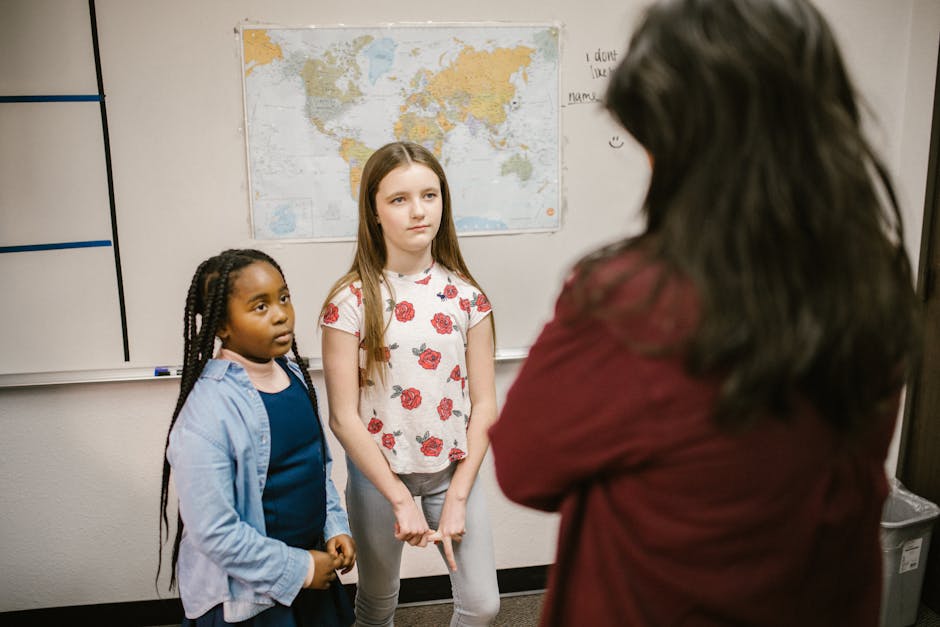 Ragazze in classe ascoltano l'insegnante, focus sull'importanza dell'educazione e del dialogo per contrastare il disagio giovanile.