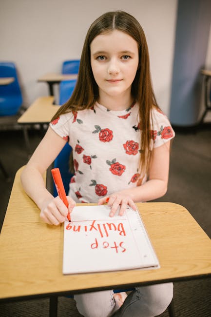 Ragazza scrive Stop Bullying su quaderno in classe dopo riposizionamento striscione di pace dal sindaco per gestione scolastica serena