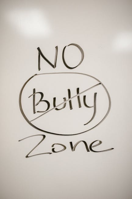 Scritta No Bully Zone su lavagna bianca, simbolo di impegno contro il bullismo e promozione di gentilezza e sensibilità nelle scuole.