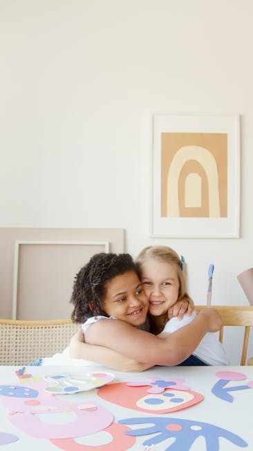 Due bambine abbracciate creano decorazioni colorate di carta, attività musicale e artistica per bambini che imparano divertendosi.