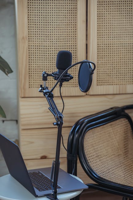 Microfono professionale con laptop per progetti di comunicazione radiofonica innovativi e creativi in studio di registrazione.