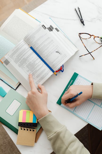 Studente che studia per i Campionati Studenteschi con libro aperto, quaderno e appunti, preparazione esami e competizioni scolastiche.