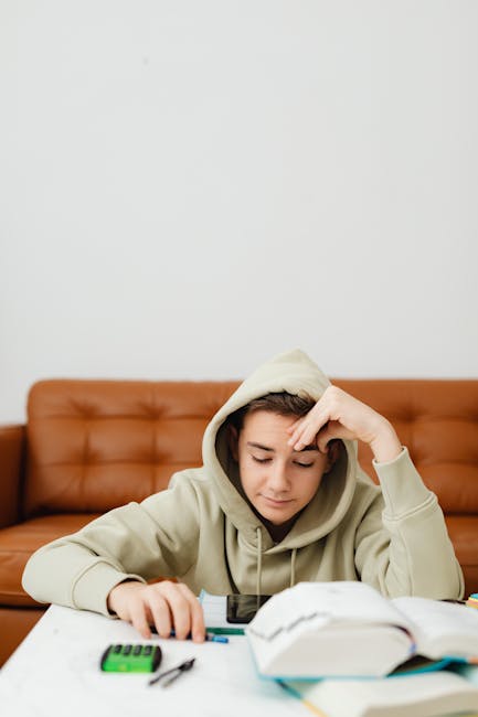 Studente pensieroso con calcolatrice scientifica e libro aperto. Migliore calcolatrice scientifica per la scuola superiore.