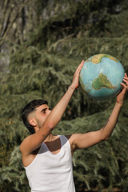 Giovane uomo che solleva un mappamondo, simbolo di responsabilità e futuro sostenibile per l'educazione alla sostenibilità globale.