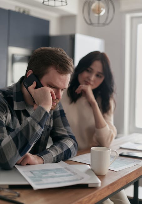 Uomo al telefono con documenti fiscali e partner preoccupata, implicazioni manovra finanziaria 2026 per famiglie e tagli fiscali