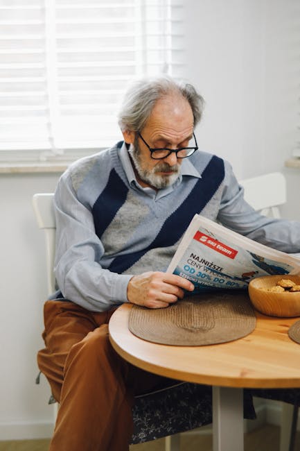 Pensionato legge il giornale a casa, informandosi sulle novità pensionistiche scuola 2026 e i requisiti per il personale scolastico.