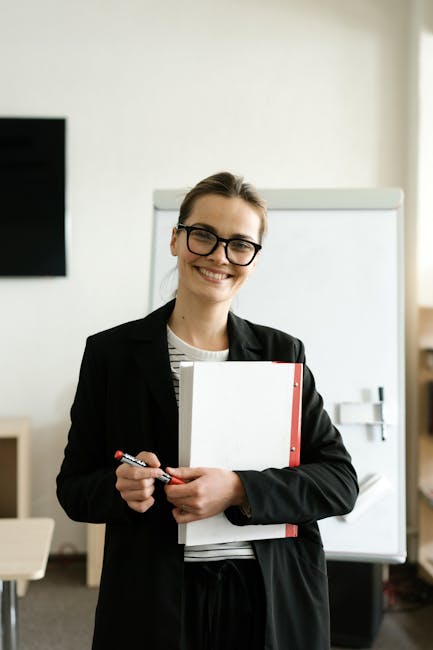 Docente sorridente con materiale didattico, Università Link nuove sedi per la formazione insegnanti e ampliamento offerta formativa.