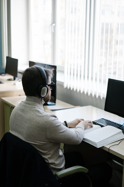 Studente con cuffie studia al computer, simbolo di autonomia e personalizzazione dell'apprendimento nel sistema scolastico italiano.