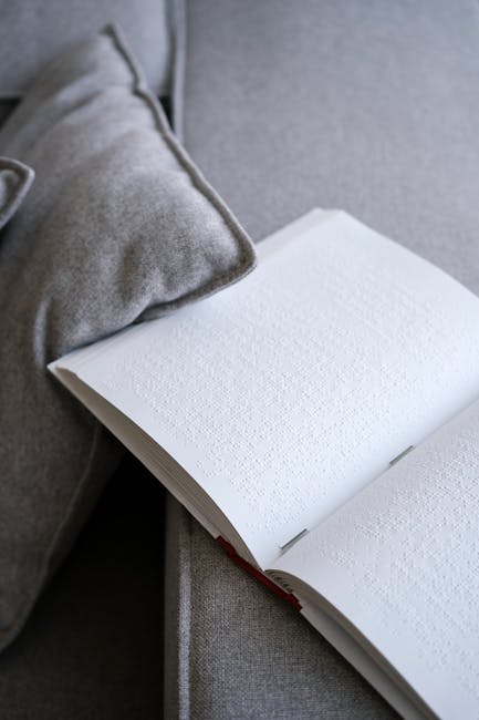 Libro in braille aperto su un divano grigio, simbolo di inclusione e accessibilità per il concorso letterario dell'Istituto Calvino di Catania