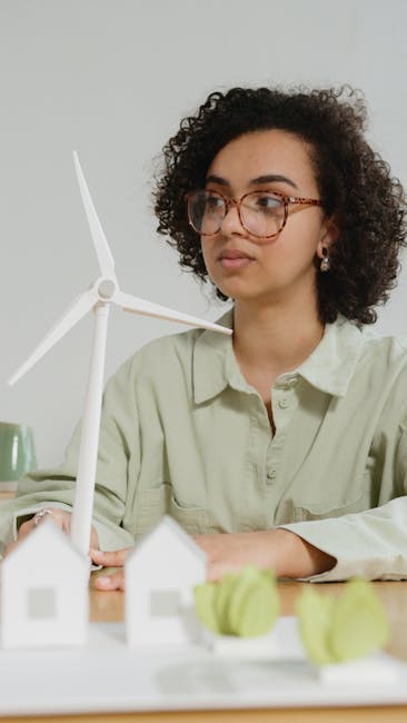Studentessa esamina modello di turbina eolica per progetto scolastico sulle energie alternative e sostenibilità