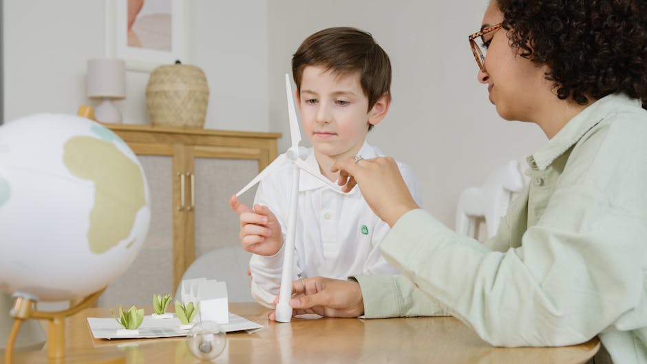 Bambino che impara l'energia eolica con un modello e l'aiuto di un'insegnante, esempio di tecnologia scolastica innovativa.