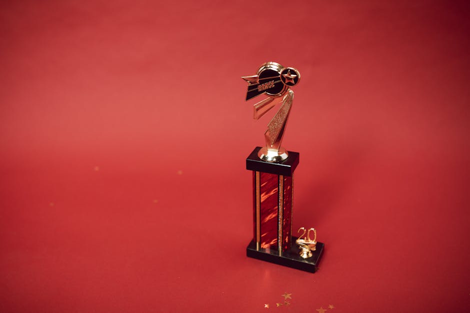 Trofeo dorato su sfondo rosso, simbolo di successo nello svolgimento degli assignments e raggiungimento degli obiettivi prefissati