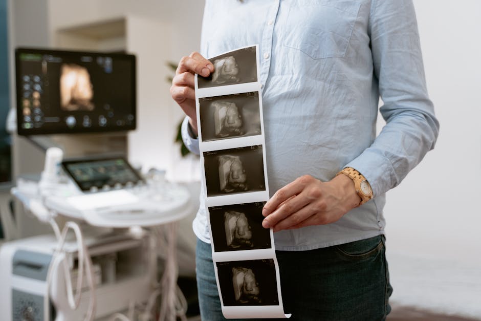 Ecografia del feto tenuta in mano da una donna incinta, simbolo di cura e attenzione prenatale, legata alla lettura ad alta voce in gravidanza.