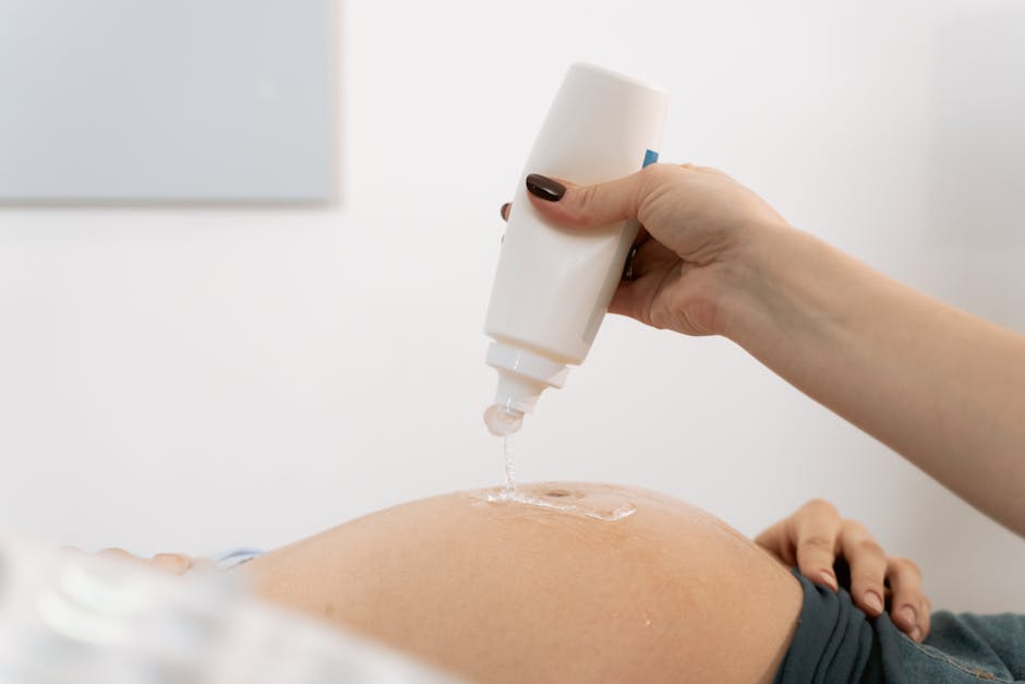 Applicazione di gel per ecografia sulla pancia di una donna incinta, concetto di cerchio e gravidanza, salute e cura prenatale