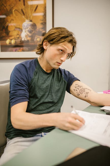 Studente concentrato con tatuaggio di formule matematiche, preparazione esame di maturità, studio filosofia e materie scientifiche