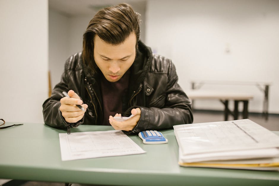 Studente concentrato durante la preparazione ai Test PISA 2025, risolvendo esercizi con calcolatrice e documenti di studio.