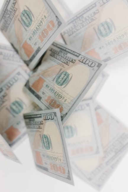 Banconote da 100 dollari USA che cadono, simbolo di liquidità e gestione del capitale circolante aziendale efficace.